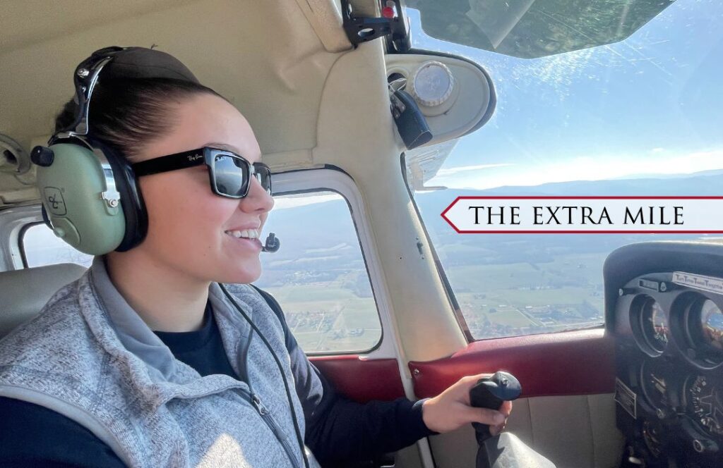 A cadet takes the wheel behind a plane and flies it in the sky.
