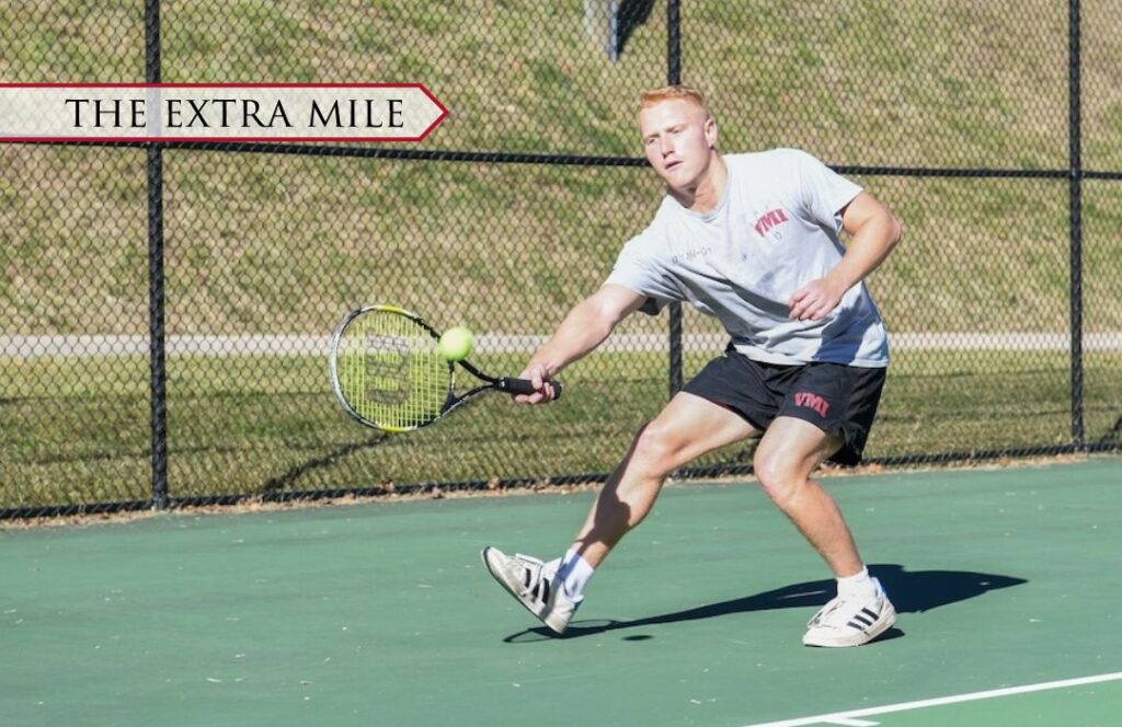 A cadet hits a ball with a raquet.