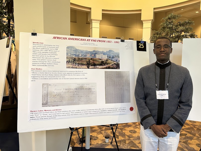Jeremiah Woods ’27 stands in front of his poster presentation.