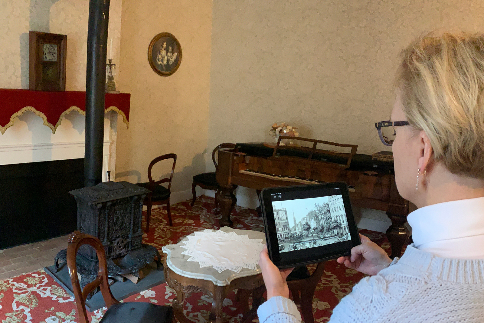 A museum visitor uses a tablet to watch a self-guided tour video.